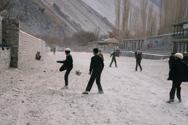 Gulmit, Pakistan. School boys playing soccer on the polo field during their lunch break. 